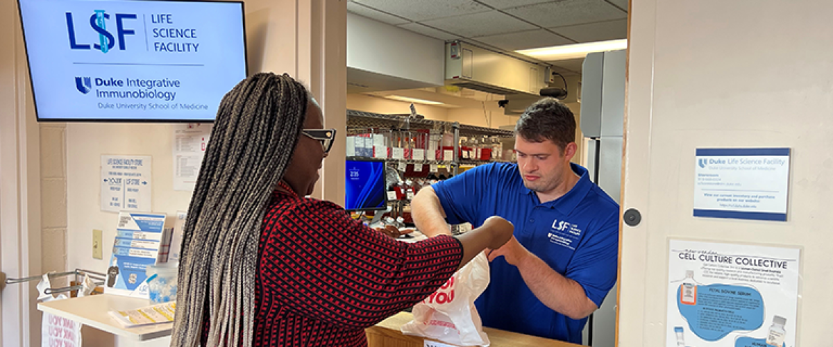 Employee selling products at the core store over an open dutch door. 